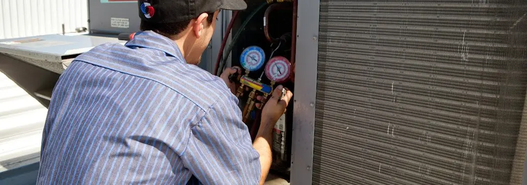 HVAC technician servicing a condenser unit in Silverdale